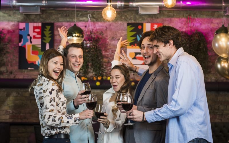 male-female-friends-enjoying-drinks-while-dancing-bar