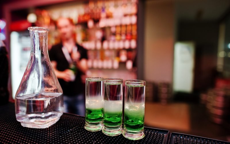 Three green mexican coctail drink and carafe background barman at the bar